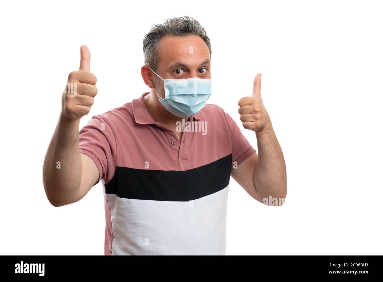 Male wearing medical disposable mask showing thumbs-up gesture as hope to protect against covid or corrona virus concept Stock Photo