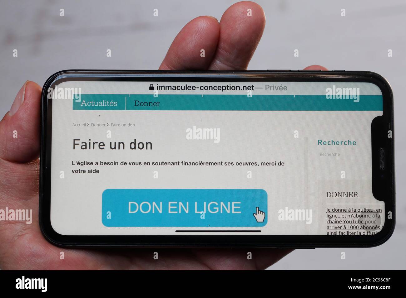 Online funding on smartphone to support the church.  France. Stock Photo