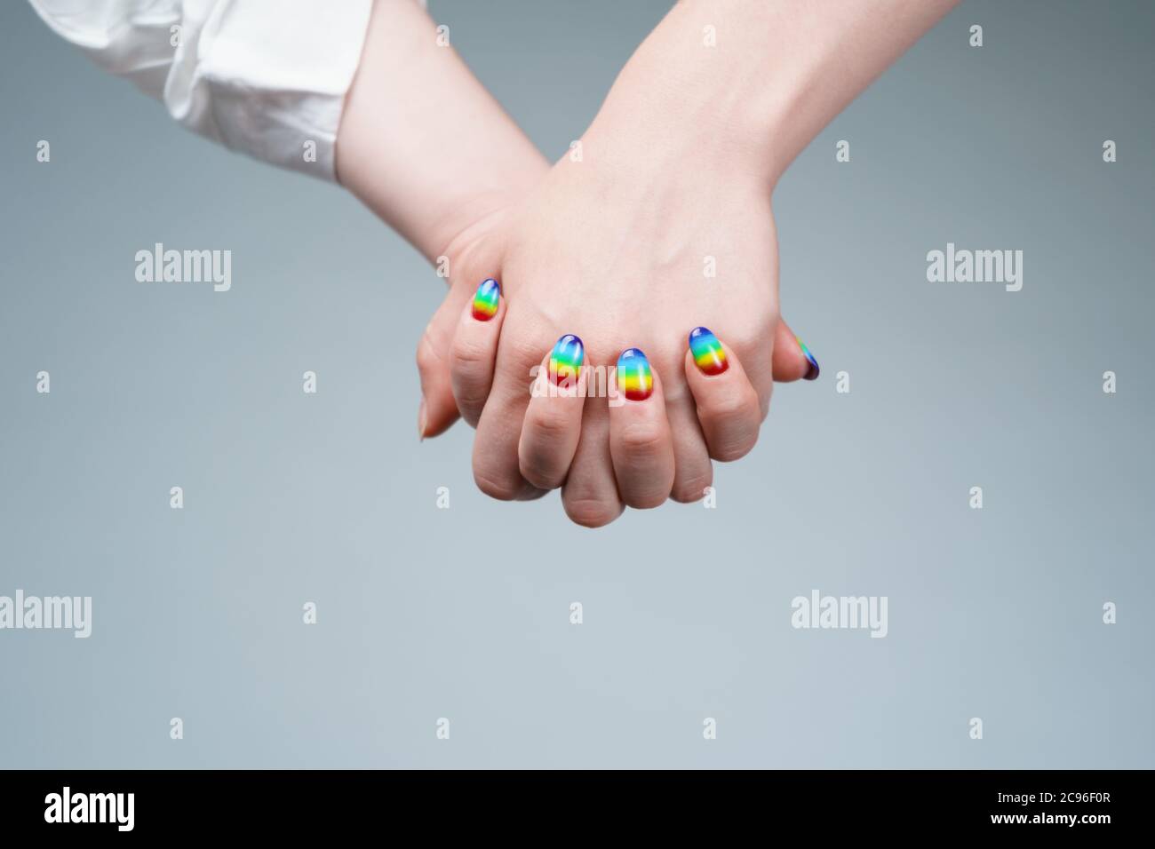 Image of woman with rainbow manicure holding hand with other woman Stock Photo