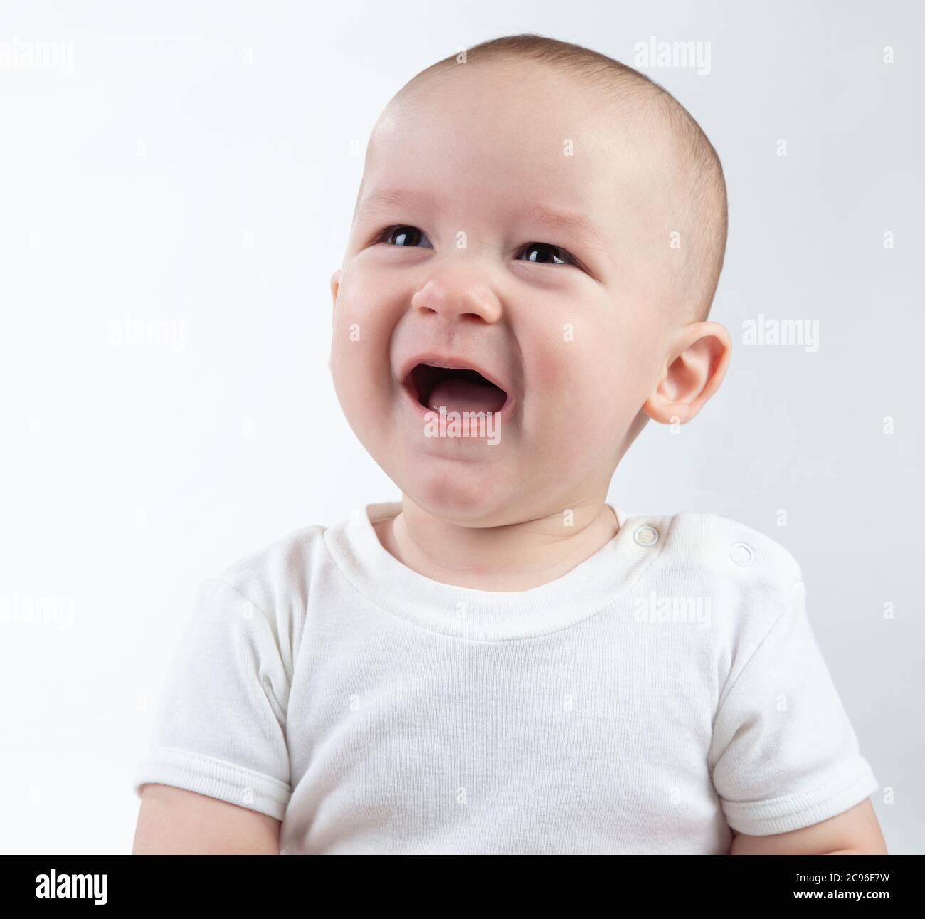 Portrait of unhappy nine-month-old baby on a white background Stock Photo