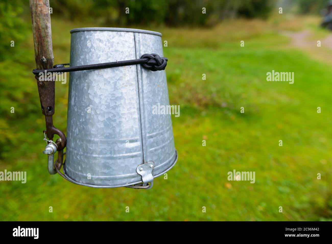 Empty metal bucket tied upside down on stick Stock Photo