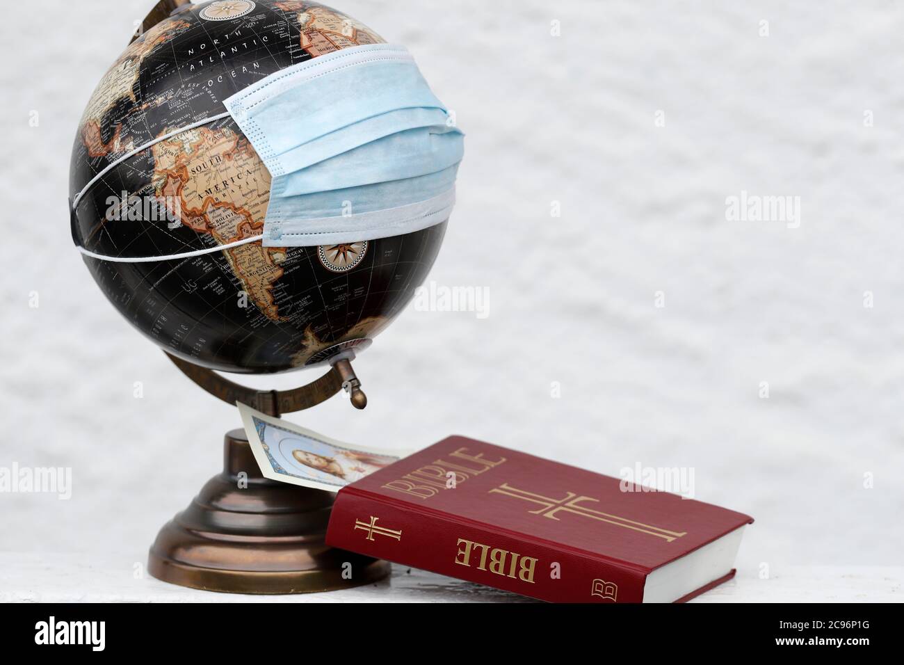 Coronavirus epidemic (covid-19). Global pandemic. Bible and world map with surgical mask. France. Stock Photo