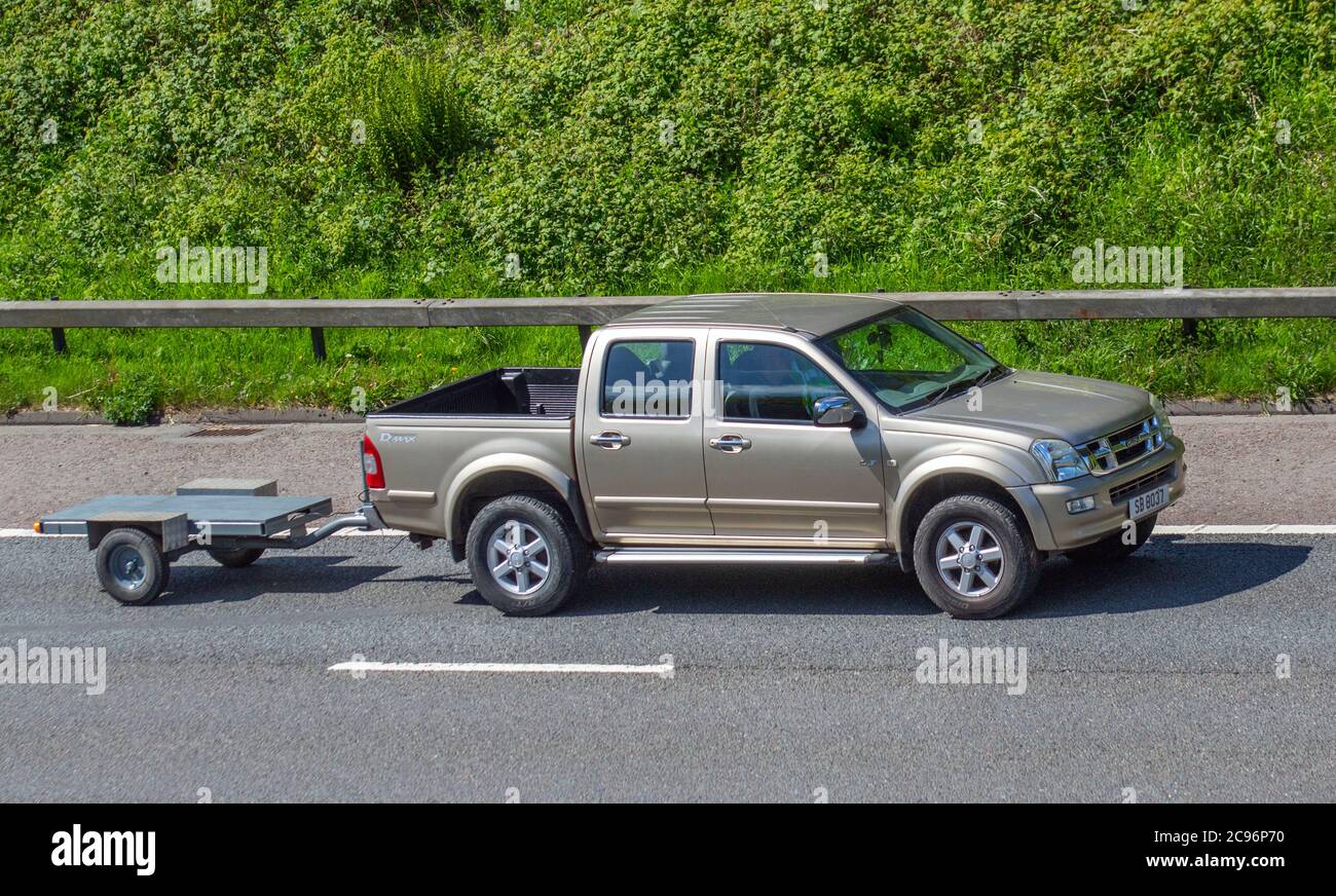 Isuzu D-Max double cab pickup Utility towing small road trailer; Vehicular traffic moving vehicles, cars driving vehicle on UK roads, motors, motoring on the M6 motorway highway network. Stock Photo