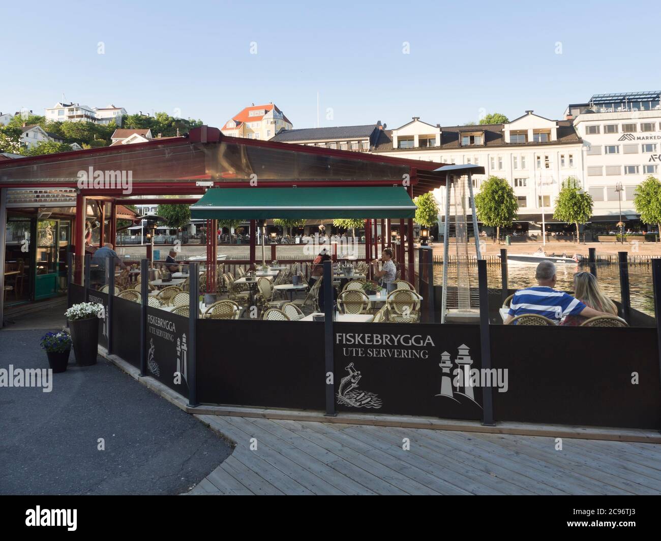 Outdoors restaurant Fiskebrygga in the harbour of Arendal Norway, before the rush of tourists set in Stock Photo