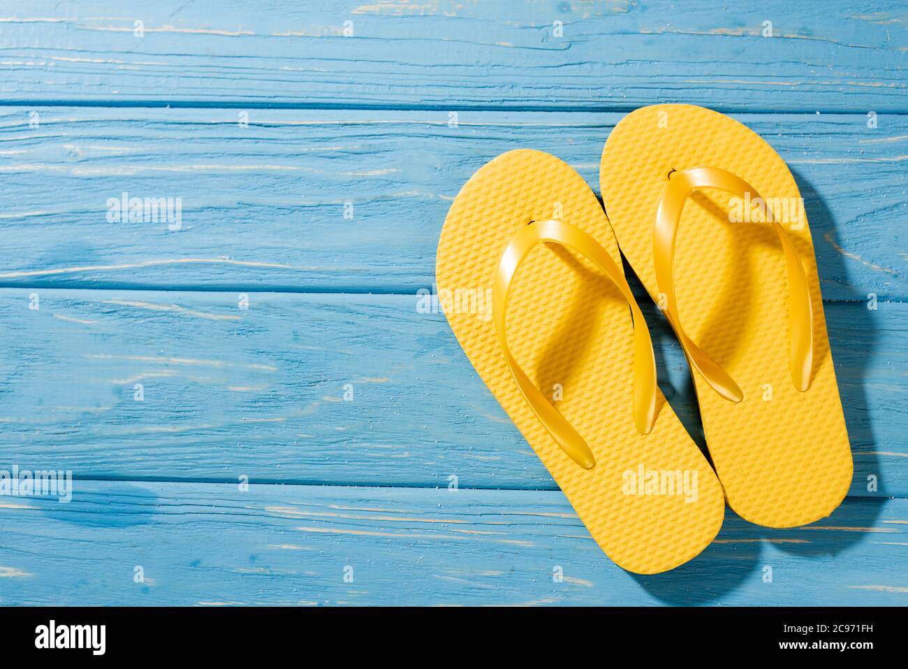 top view of yellow flip flops on wooden blue background Stock Photo - Alamy