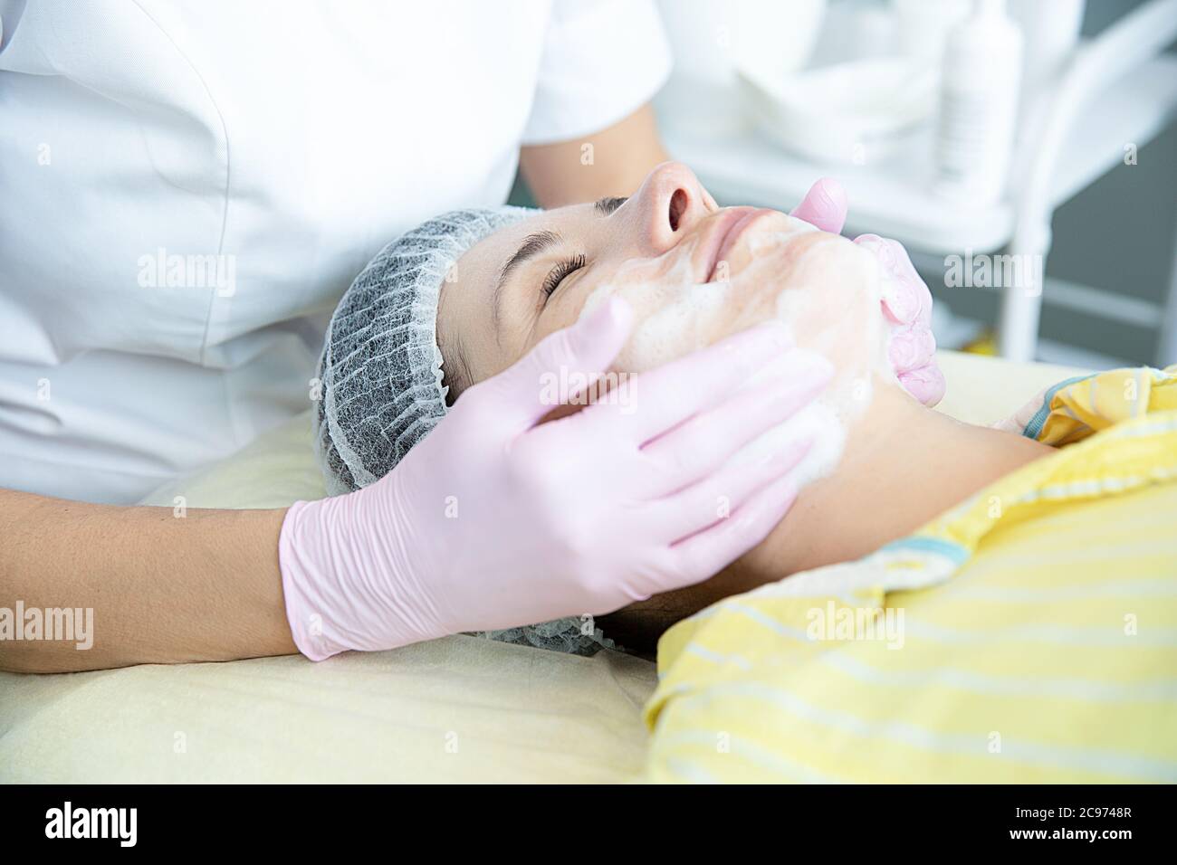 A closeup of the cleaning procedure in the office of cosmetology. Cleaning of the skin with