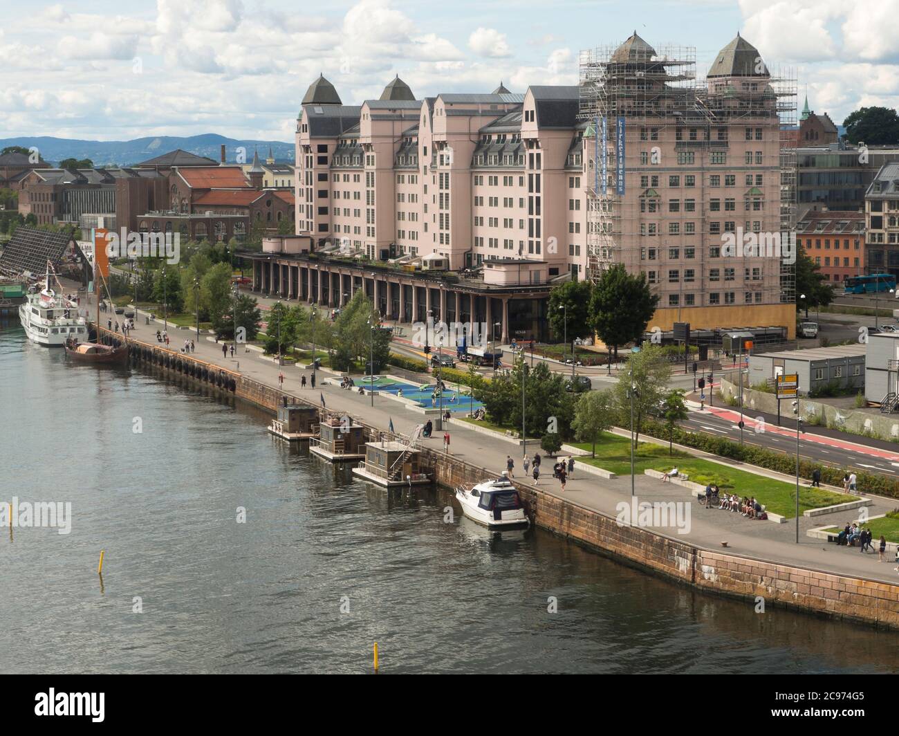 Bjorvika, part of the ca 10 kilometer long harbor promenade along the fjord through the centre of Oslo Norway  with the Havnelageret pink office block Stock Photo