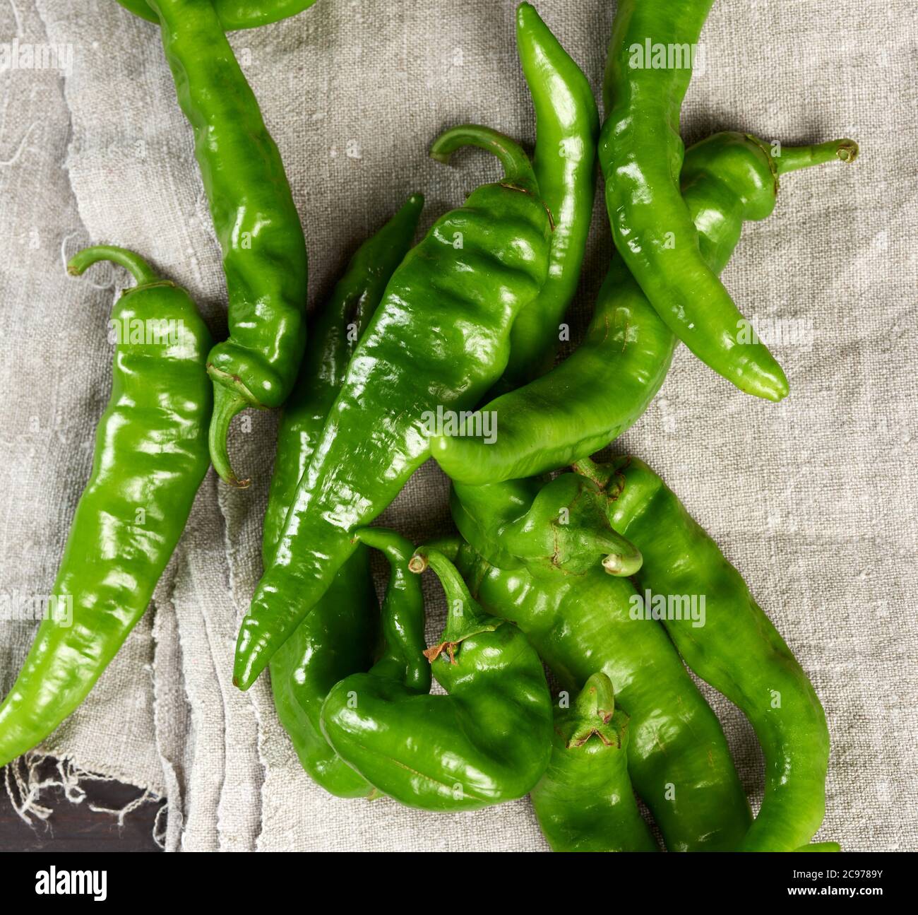 green hot pepper pods on a brown wooden table, top view Stock Photo - Alamy