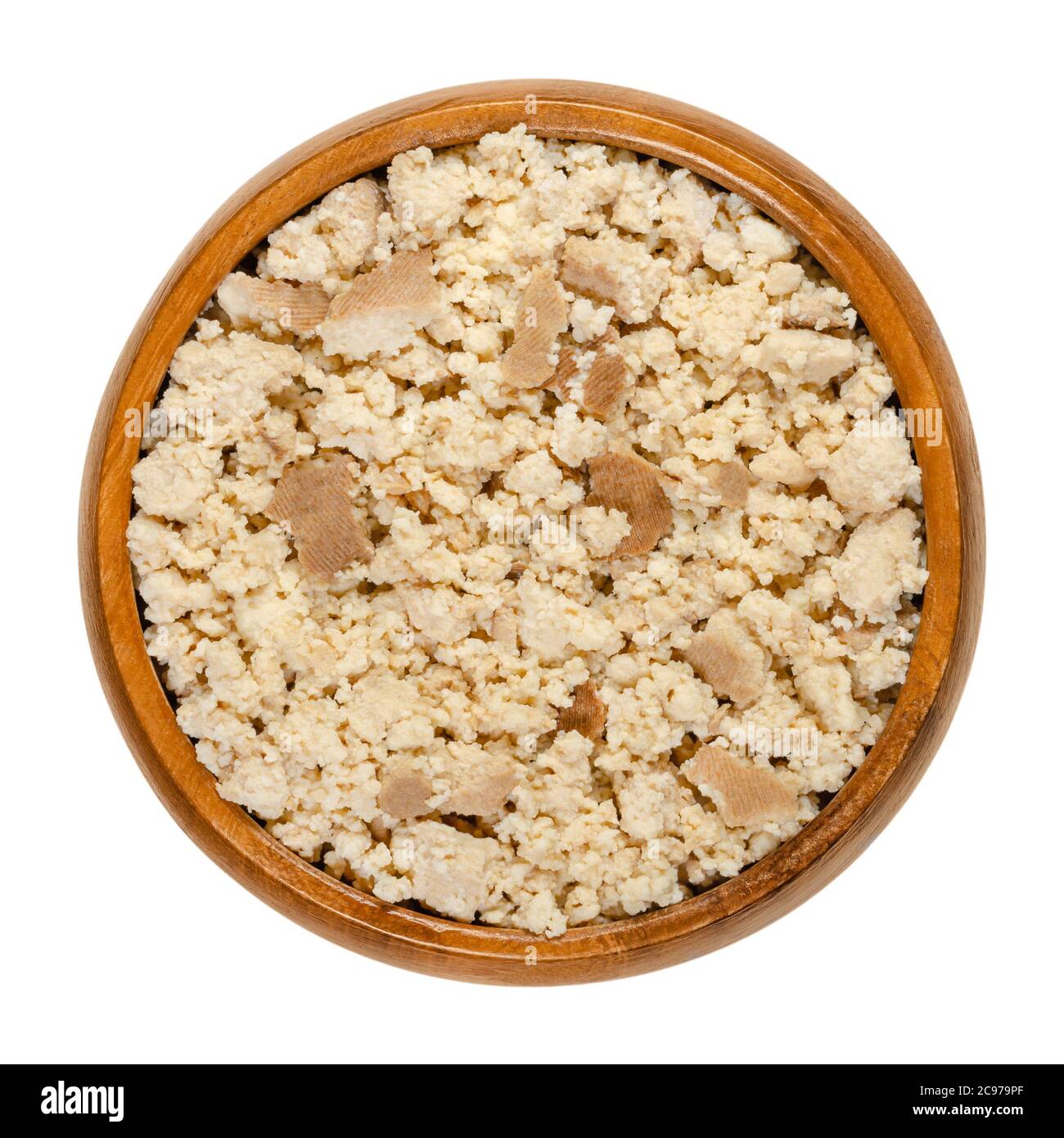 Smoked tofu, bean curd, crumbled by hand, in a wooden bowl. Coagulated soy milk, a component of Asian cuisine and meat substitute. Close-up from above Stock Photo