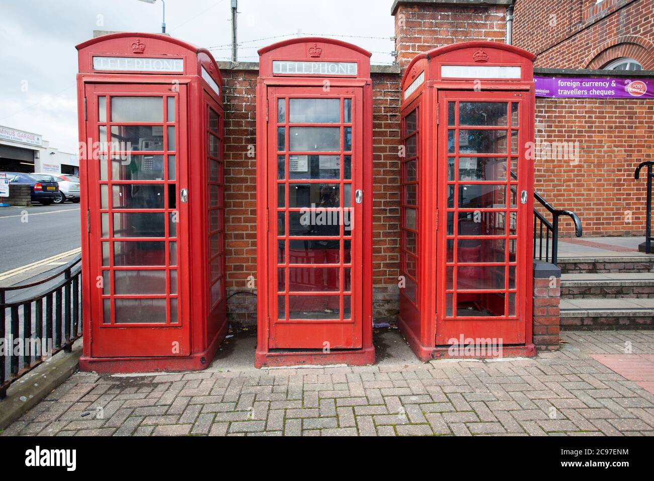 Three red phonet boxes standing side by side on a street in the UK. Stock Photo