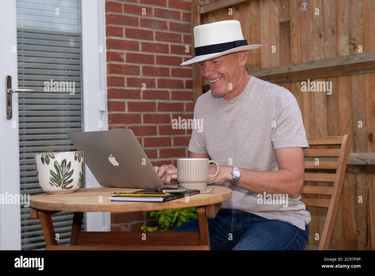 Happy man using laptop in garden Stock Photo