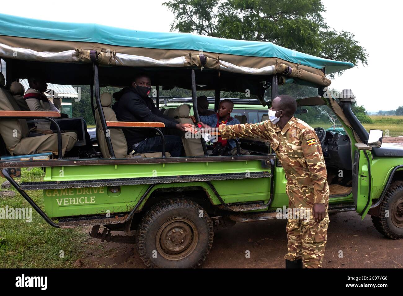Kaabong. 29th July, 2020. A national park ranger (R) sanitizes hands of a  tourist before a game drive in Kidepo Valley National Park in Kaabong  district in northeast Uganda, July 29, 2020.