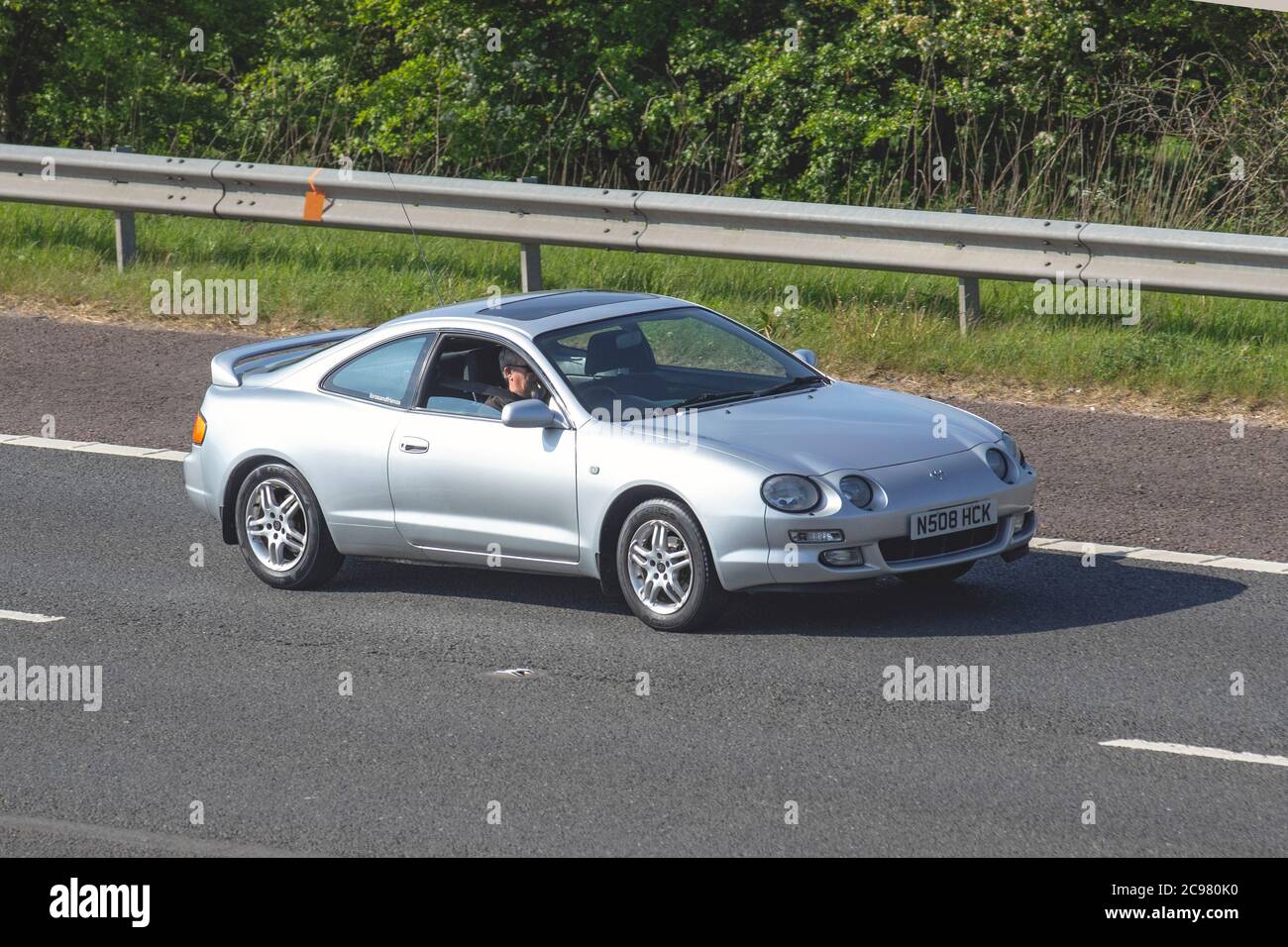 1996 90s silver Toyota Celica ST; Vehicular traffic moving vehicles, cars driving vehicle on UK roads, motors, motoring on the M6 motorway highway network. Stock Photo
