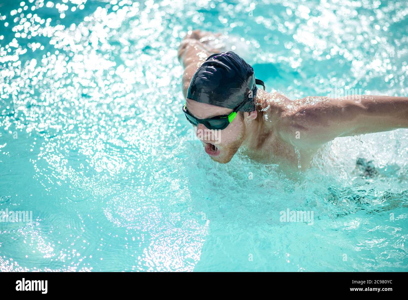 Man in swimming goggles having a workout in pool Stock Photo