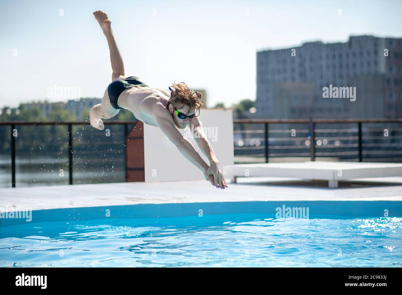 Swimmer at the time of jump in open pool Stock Photo