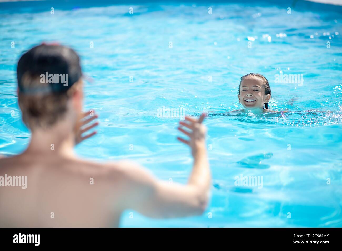 Instructor backs and swimming boy in pool Stock Photo