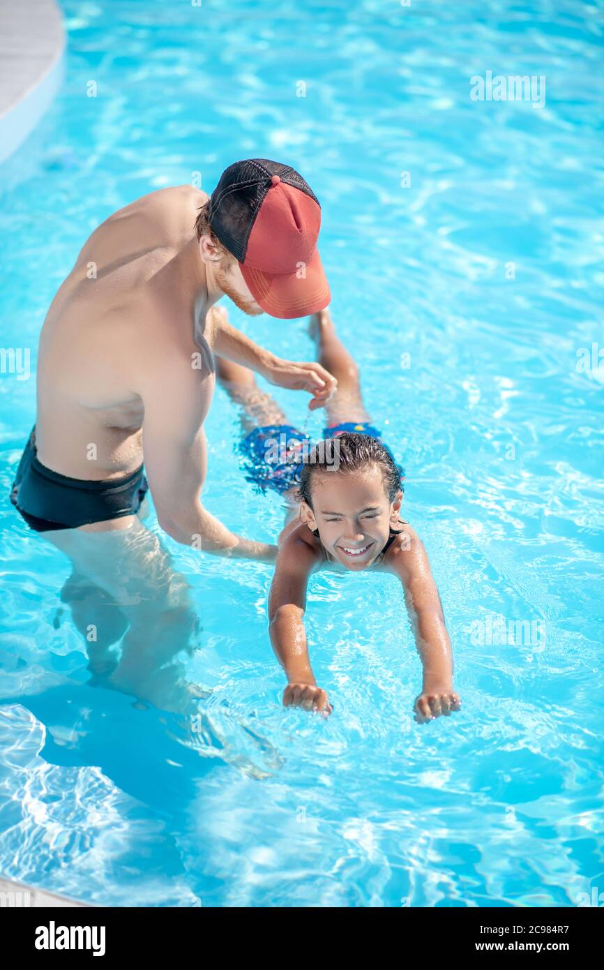 Instructor teaching a boy to keep afloat Stock Photo