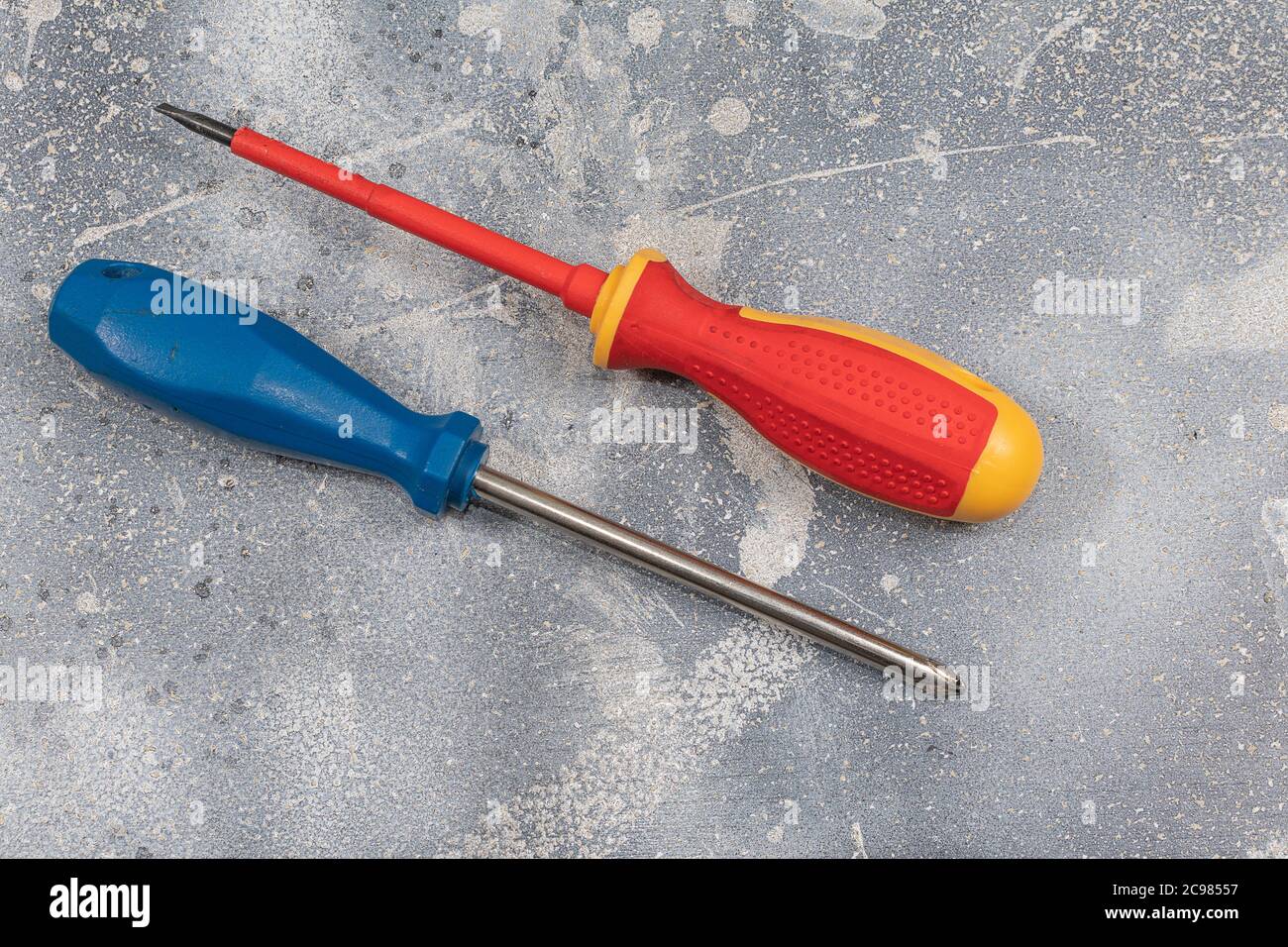 One Phillip and one Standard cabinet tip screwdriver, ergonomically designed, efficient hand-tool for turning -driving- screws, isolated close-up on r Stock Photo