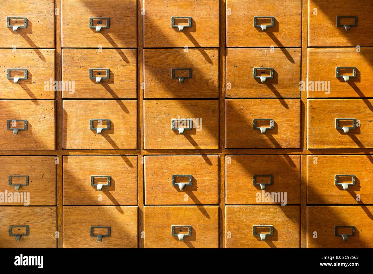 A vintage unit of small drawers / chest of drawers with numerous drawers perhaps use for record keeping cards and filing. Hardwood furniture and antiques. (119) Stock Photo
