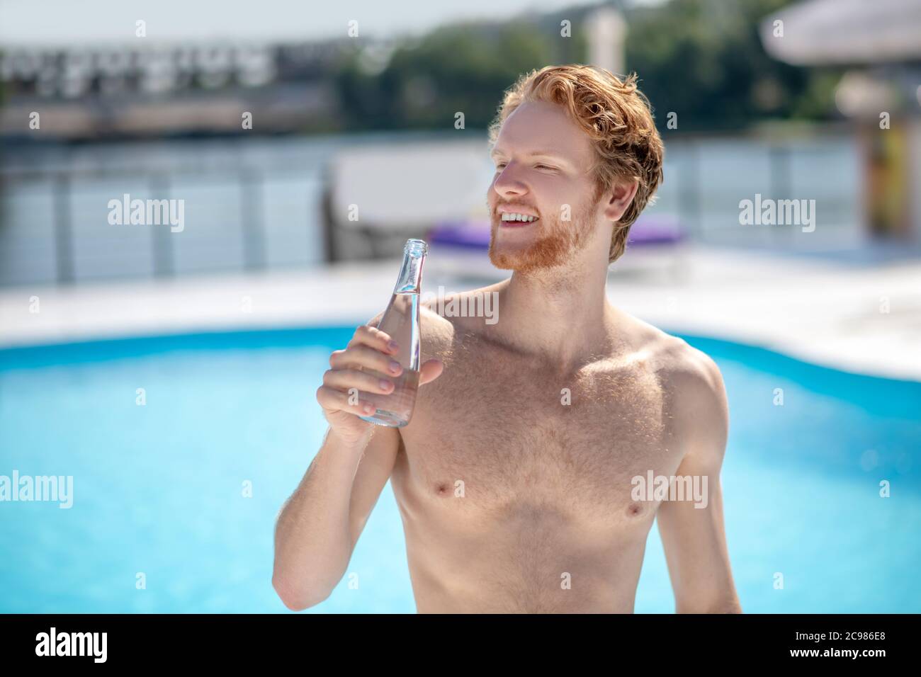 Man holding bottle of drinking water to his face Stock Photo