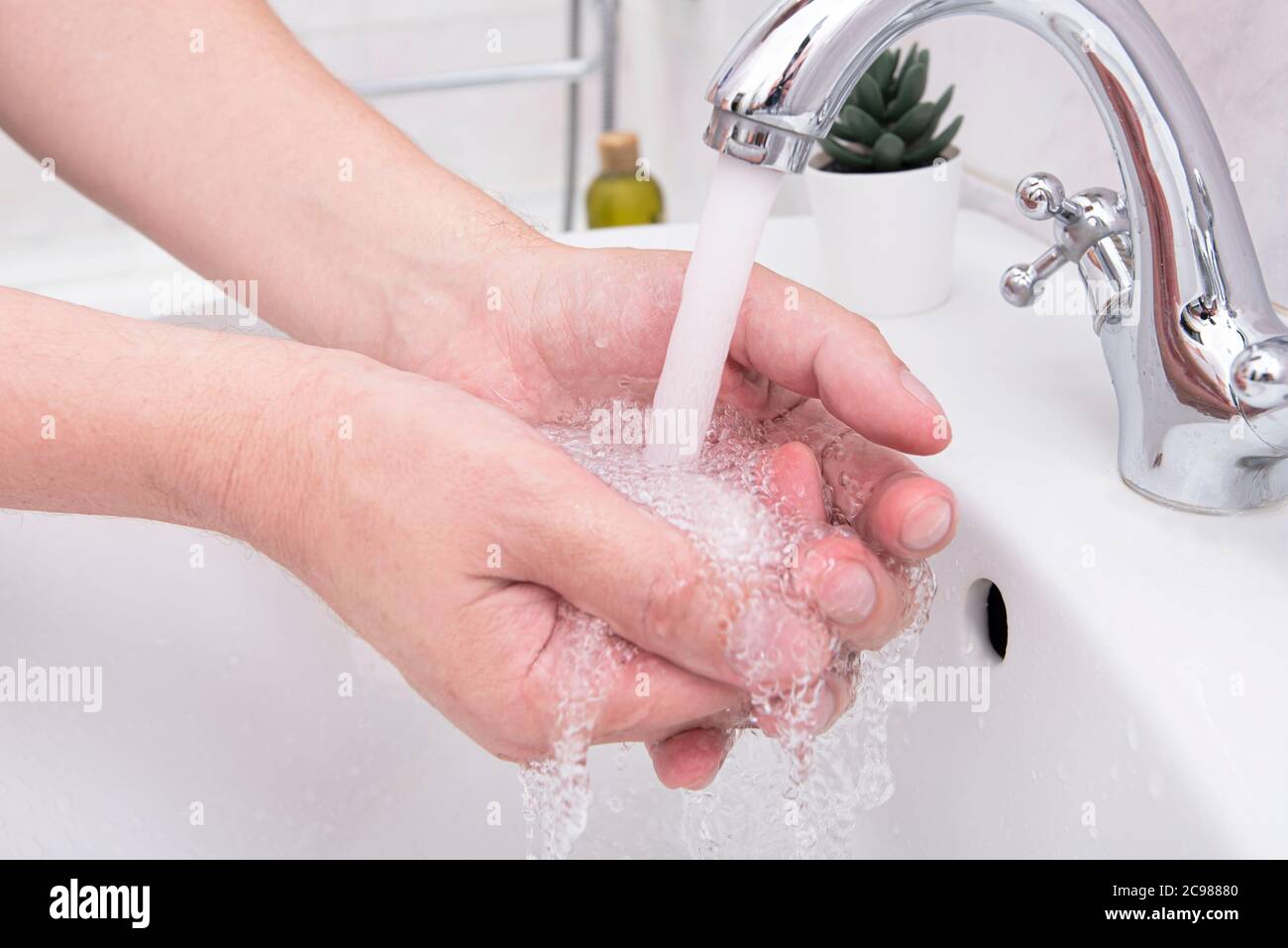 Man washing his hands, closeup hands of man at bathroom with soap and