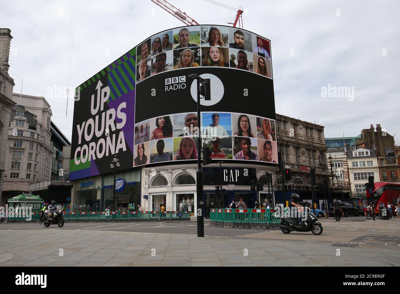 Radio 1 'Up Yours Corona' campaign is displayed on the Piccadilly Lights screen. The 10 minute long display features one person from every country in the world. Stock Photo