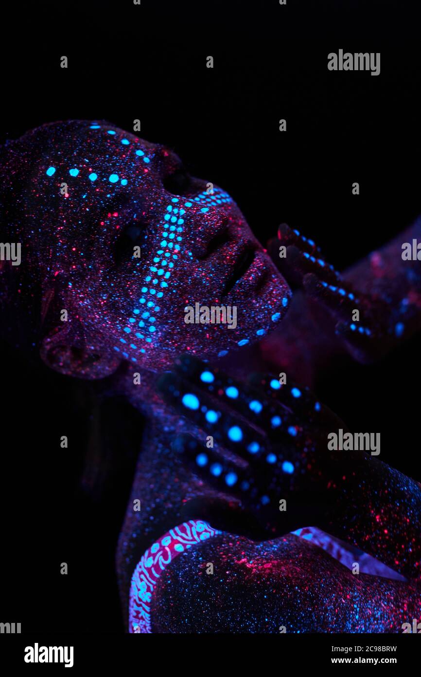 Art girl cosmos in ultraviolet light. Woman does yoga, body warm-up. Entire  body is covered with colored droplets. Astral yoga. Noise, out of focus  Stock Photo - Alamy
