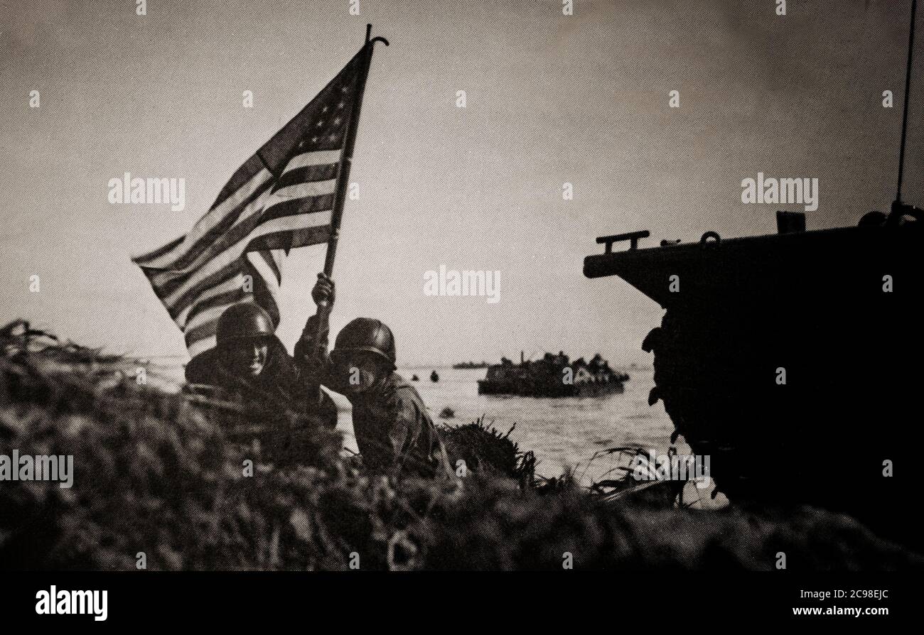 US Marines flying the Stars and Stripes on Guam Beach during the Second Battle of Guam (21 July – 10 August 1944), the American recapture of the Japanese-held island of Guam, a U.S. territory in the Mariana Islands captured by the Japanese from the U.S. in the 1941 First Battle of Guam during the Pacific campaign of World War II. Stock Photo