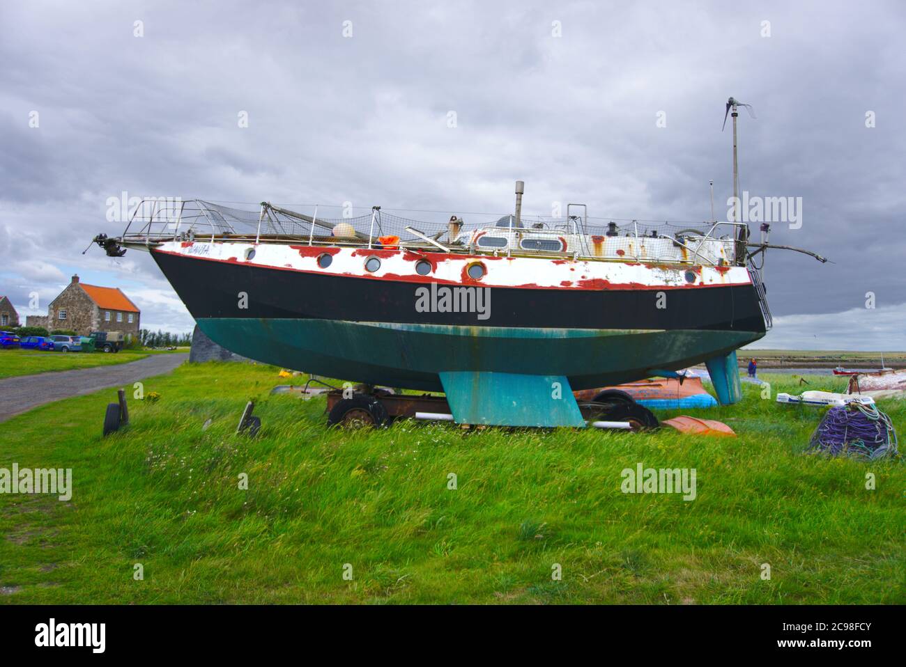 Boat moored on grass near Holy Island harbour, Lindisfarne, Northumberland. Stock Photo