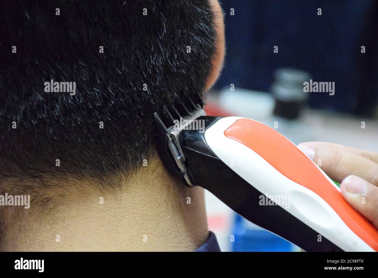 Soft Focus to Men's hairstyling and haircutting with hair clipper in a barber shop Stock Photo