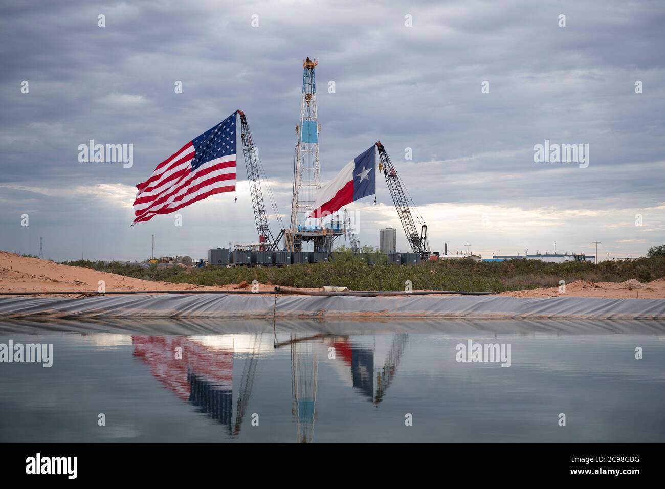 Midland, Texas, USA. 29th July, 2020. The Texas and USA flags adorn a  drilling rig site southeast of Midland, TX where U.S. President Donald  Trump (not shown) will visit July 29, 2020