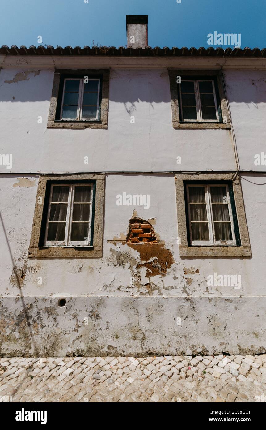 Vertical low angle shot of the facade of an old house with a damaged ...