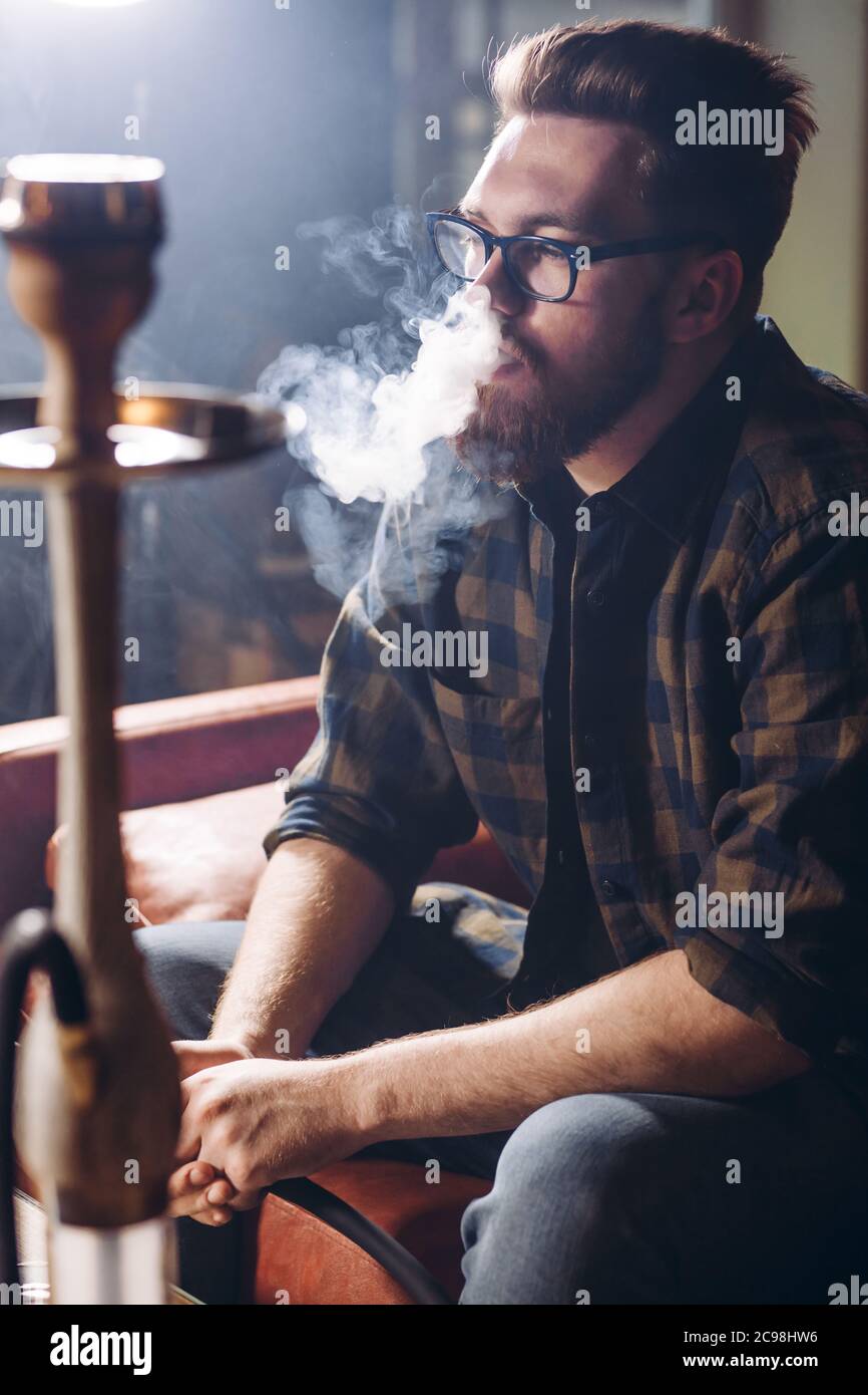 thoughtful man looking at the smoke from the hookah. close up side view  photo. man thinking about his problems while smoking Stock Photo - Alamy, image size:866x1390