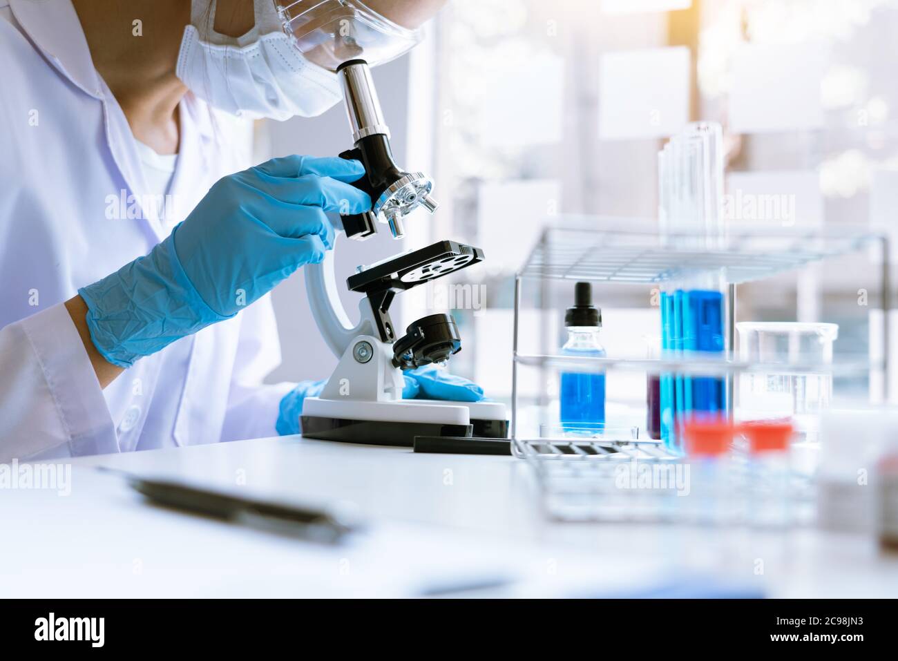 Young Asian scientist Working looking through a microscope doing ...