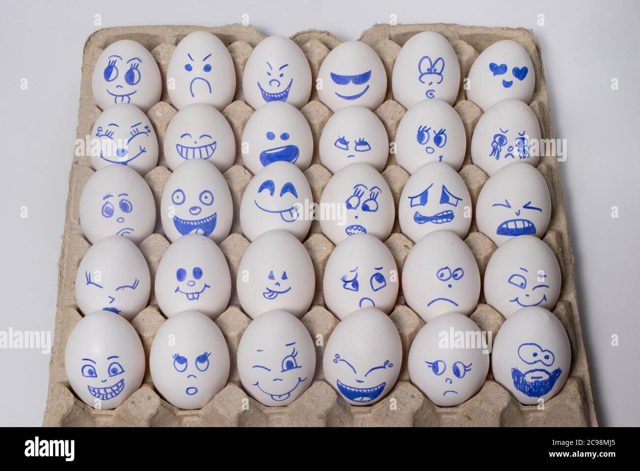 Funny chicken eggs. Smiley eggs with faces, funny faces. Eggs with different emotions: laughter, smiles, fear, anger, scream, tears. Stock Photo