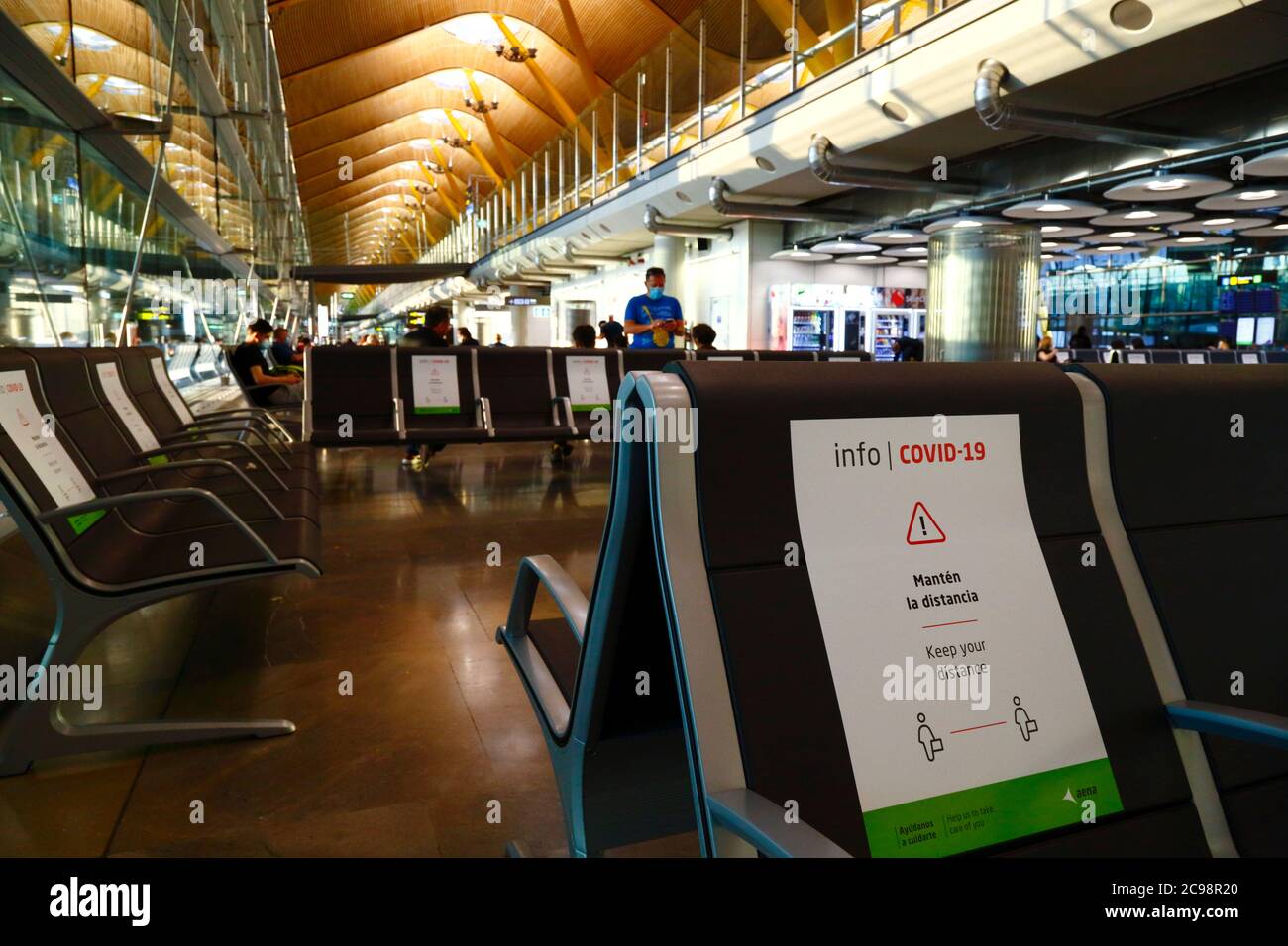 28th July 2020, Barajas Airport, Madrid, Spain: Signs on seats to help passengers comply with social distancing in the near empy departure lounge area of the Terminal 4S building of Barajas Airport. Reduced numbers of flights are now operating between European countries after the lockdown to control the covid-19 coronavirus, and governments have put a system of air bridges in place to facilitate travel and tourism. Spain has seen a number of new outbreaks in recent days, prompting the UK government to announce that people returning to the UK from Spain should quarantine for 14 days on arrival. Stock Photo