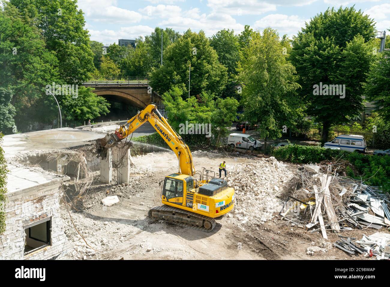 Berlin, Germany - july 13, 2020: A building site in Berlin with a yellow excavator demolishing a house Stock Photo