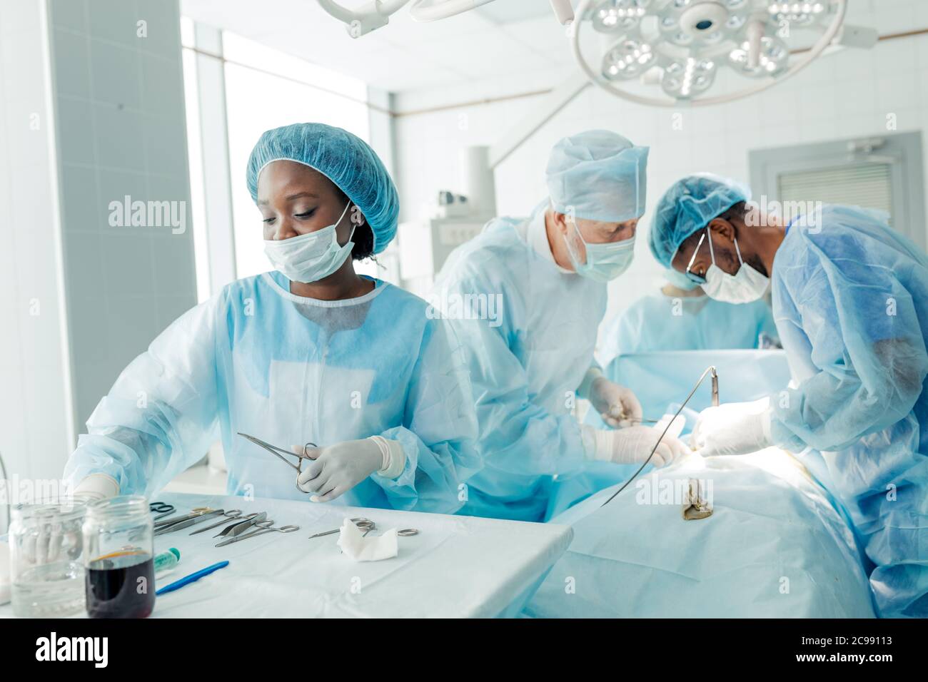 nurse and team of talented doctors using cutting and dissecting