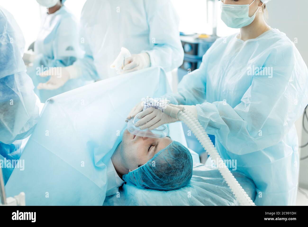 skilled doctor using respiratory equipment to restore lungs function of man. close up side view photo Stock Photo