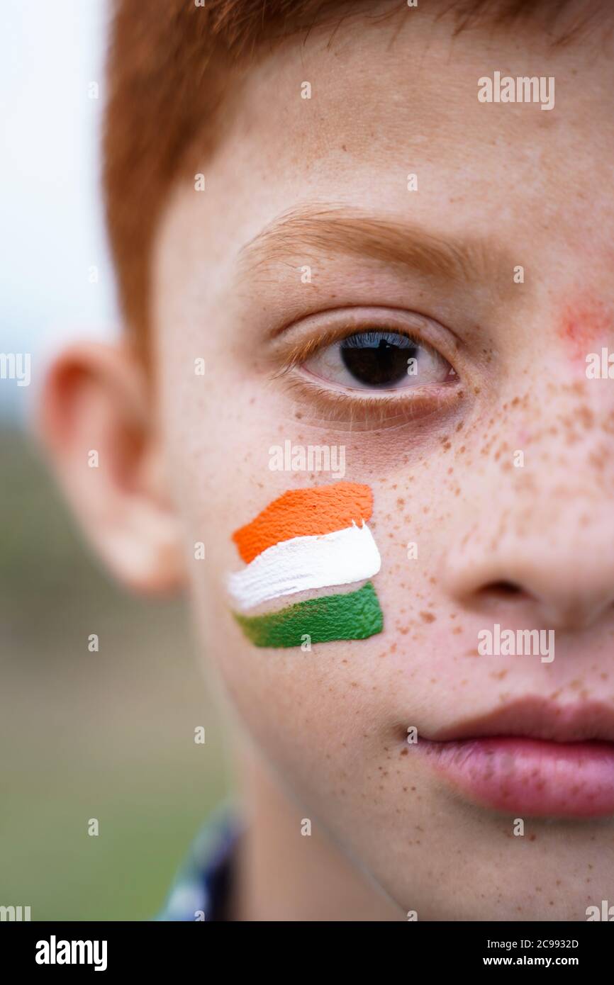Closeup of Tricolor Indian flag Painted on Kid face during Indian Independence day - concept of patriotism or support for country Stock Photo