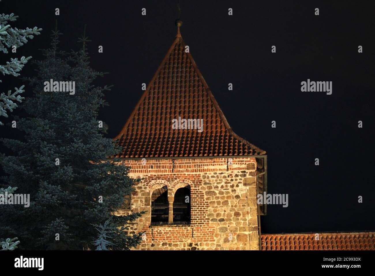Church with evening lighting with fir trees in the foreground Stock Photo