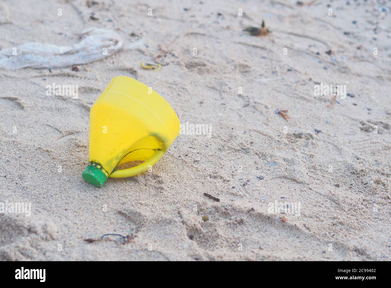 Yellow Plastic bottle on Beach Pollution Environment Stock Photo