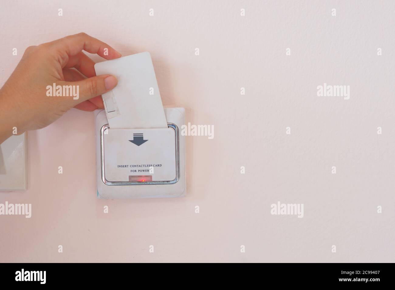 Soft Focus on Hand insert key card for on power electric equipment in the hotel room, Hotel Lock Energy Control System Stock Photo