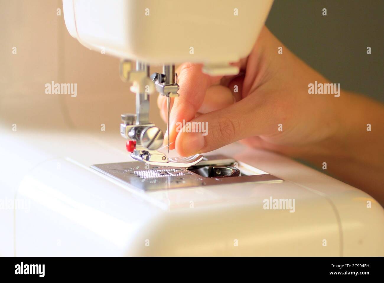 Preparing the sewing machine for work. Seamstress tucks thread into the
