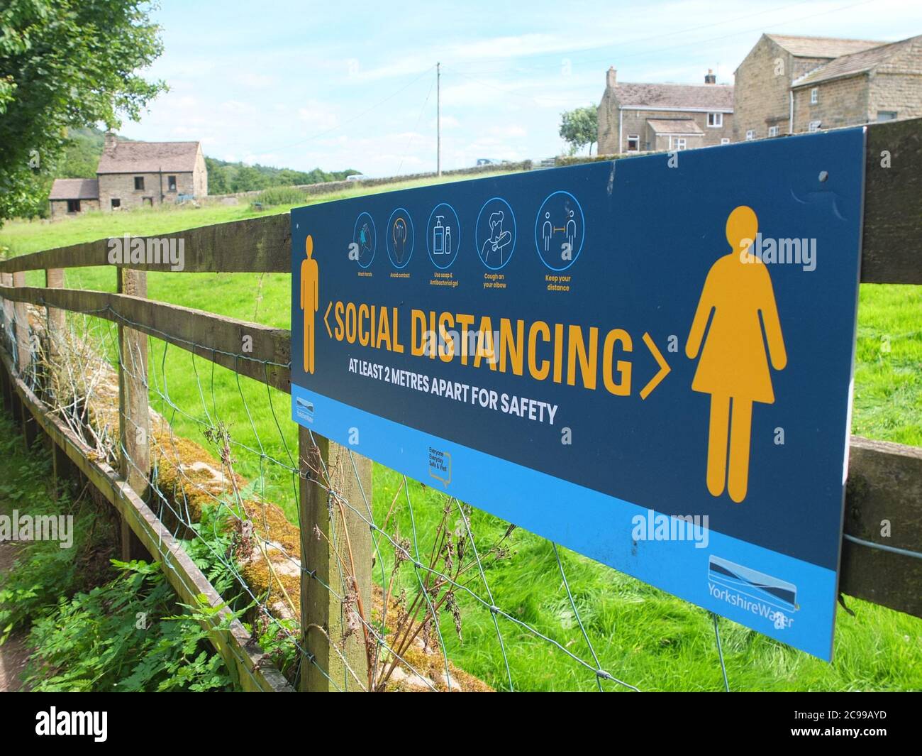 Sign advising social distancing measures in the Peak District countryside at Damflask Reservoir, Low Bradfield nr Sheffield UK with a rural background Stock Photo