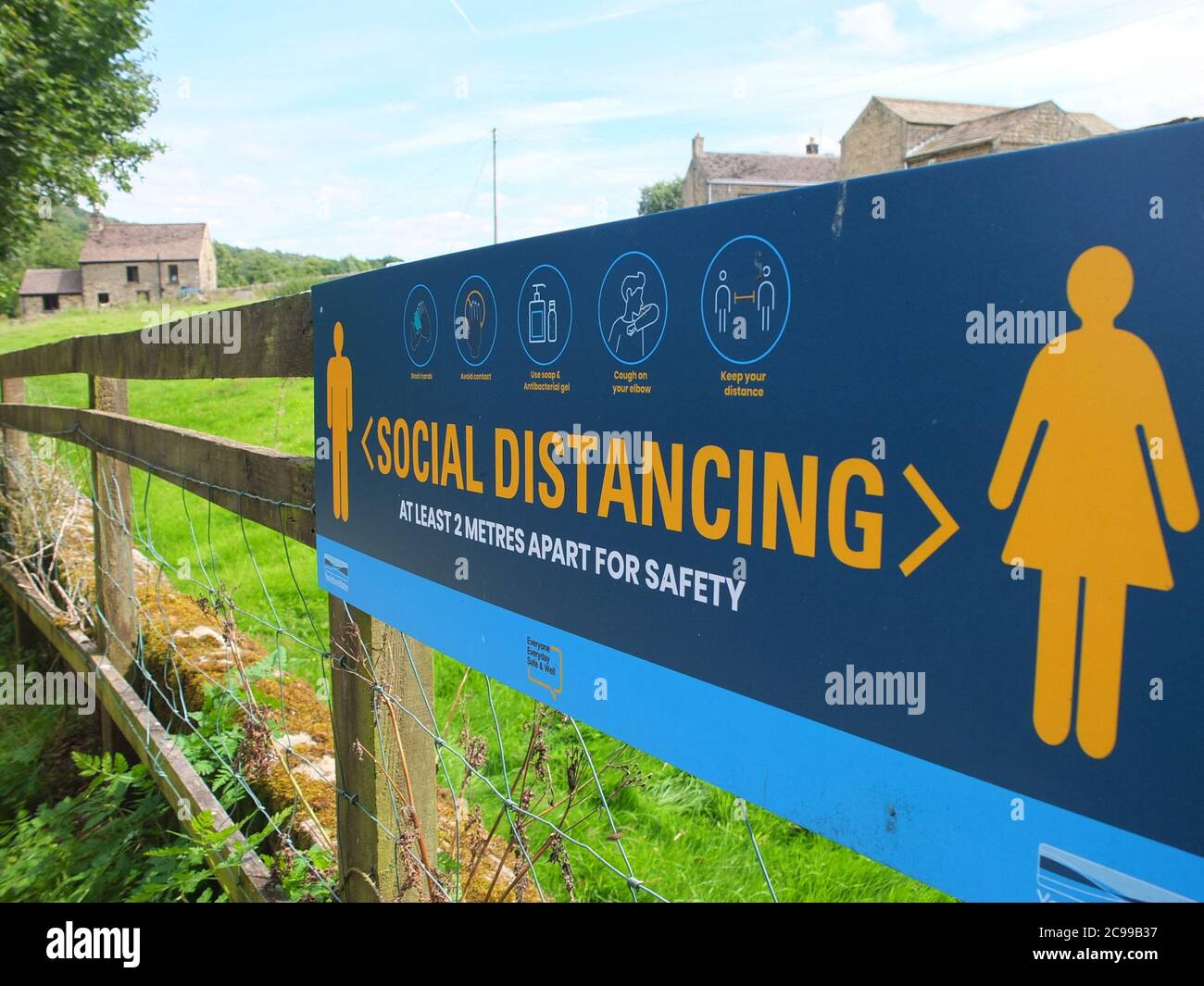Sign advising social distancing measures in the Peak District countryside at Damflask Reservoir, Low Bradfield nr Sheffield UK with a rural background Stock Photo