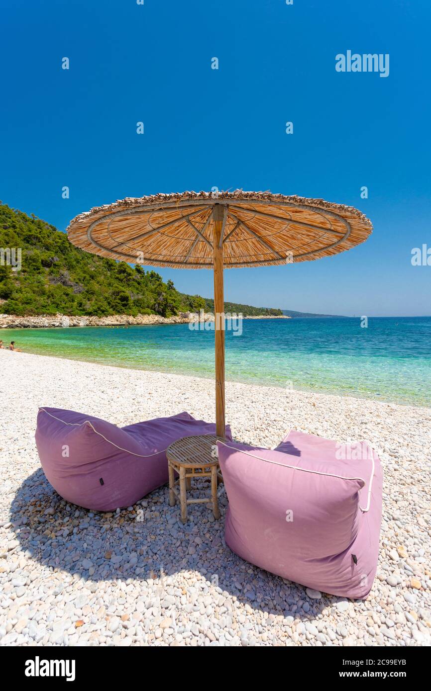 Sun loungers and umbrella on Leftos Gialos beach, Alonnisos, Greece Stock Photo