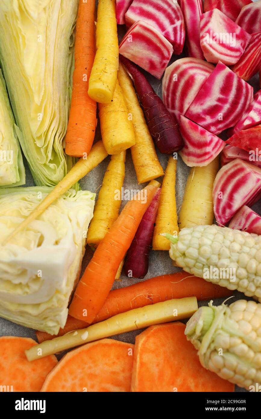 Fresh vegetables laid out to roast in an oven. Corn, carrot, sweet potato, chioggia beet and cabbage. Photo Jeppe Gustafsson Stock Photo