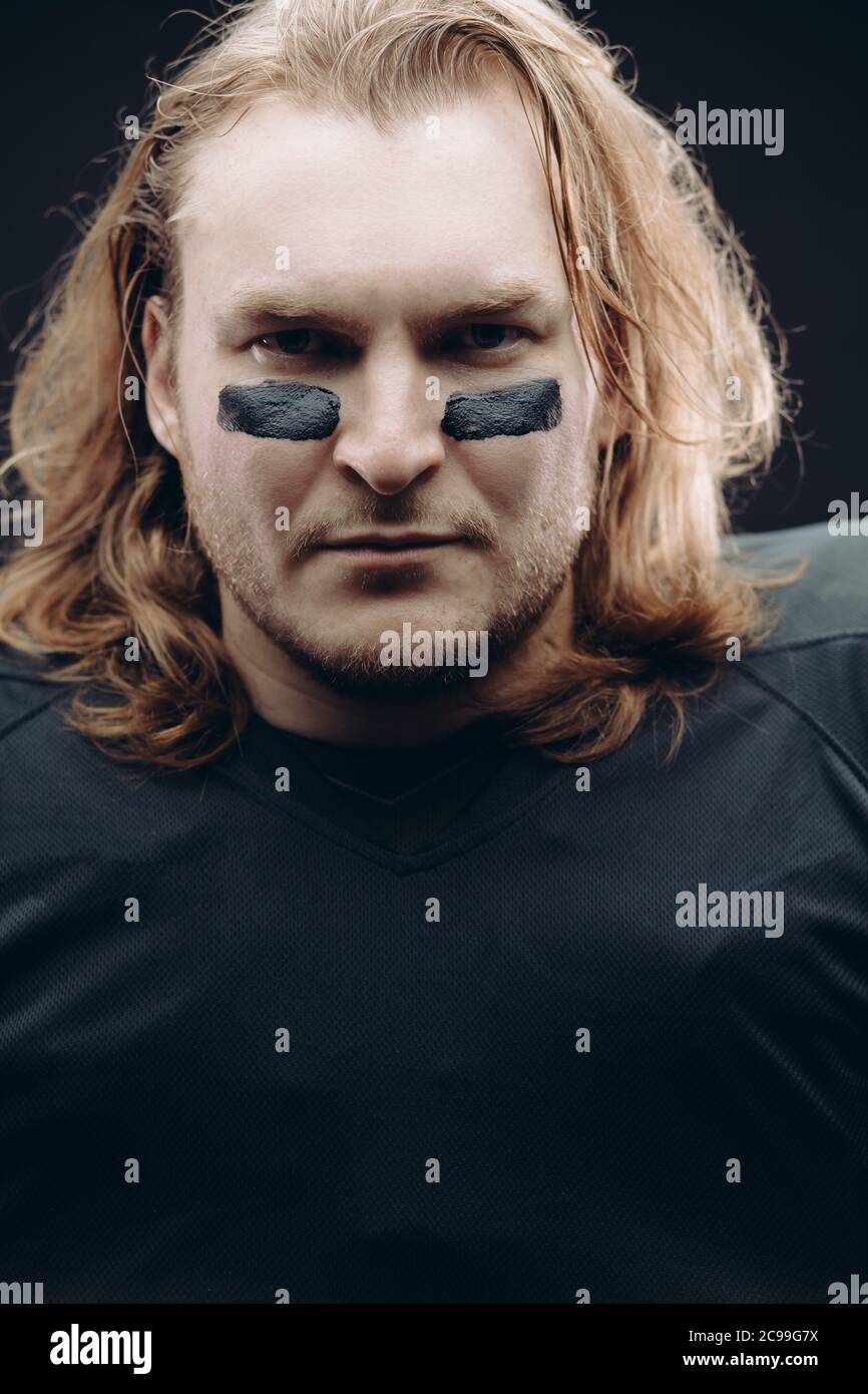 Portrait of determined caucasian blonde American football sportsman in
