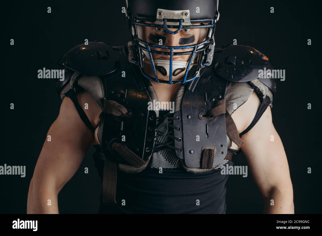 American Football Player With Ball Wearing Helmet And Protective Shields Isolated Over Black Background Close Up Stock Photo Alamy
